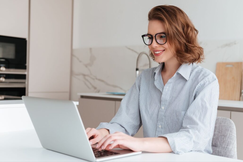 The woman with the glasses smiles and works 