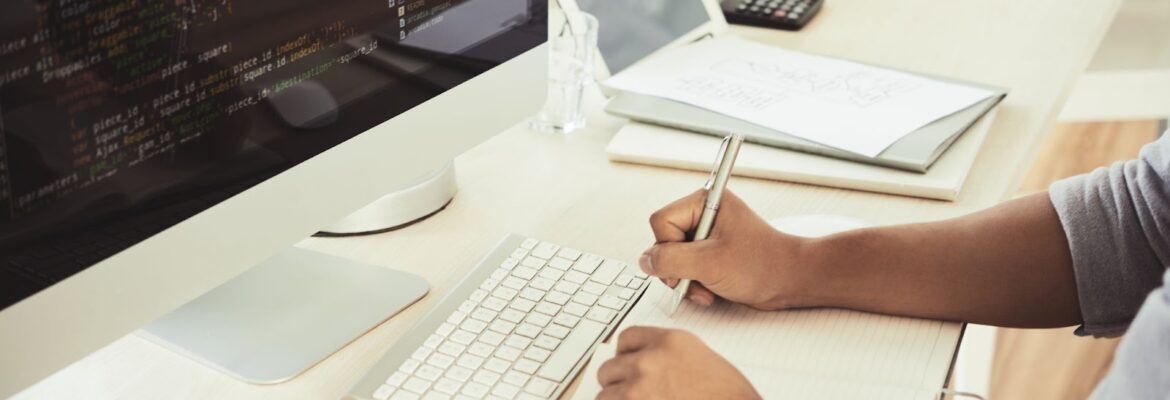 A man works on the code and records the data in a notebook